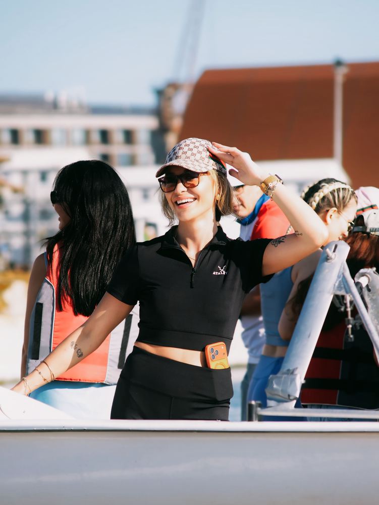 Sailors on the deck of a boat with a marina behind them